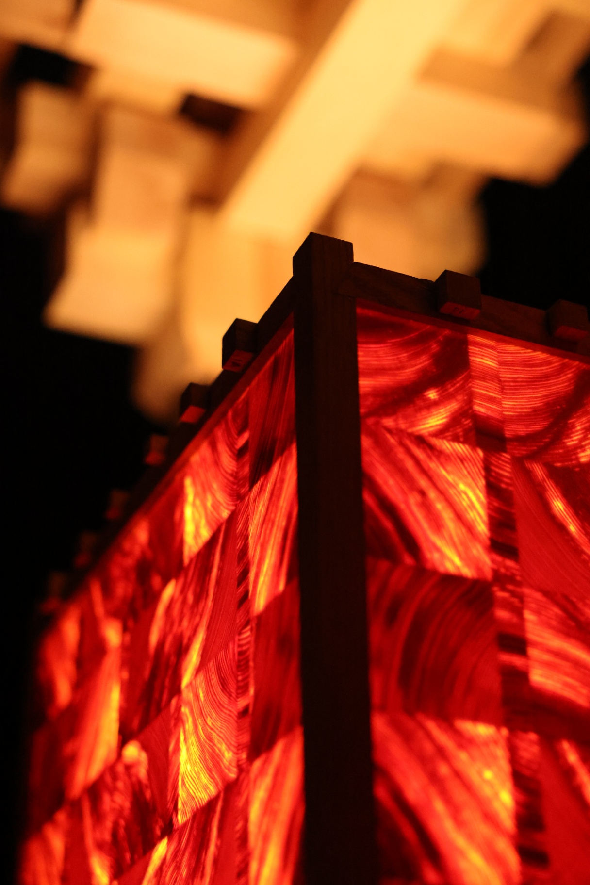 PASSAGE corner where the dark frame meets glowing end-grain panels