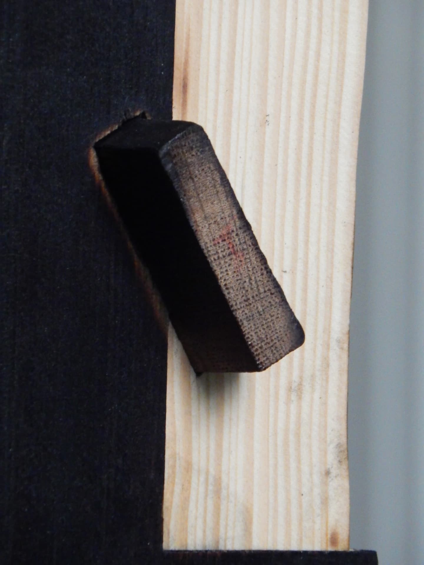 PASSAGE joinery detail — dark wooden peg locking into pale timber