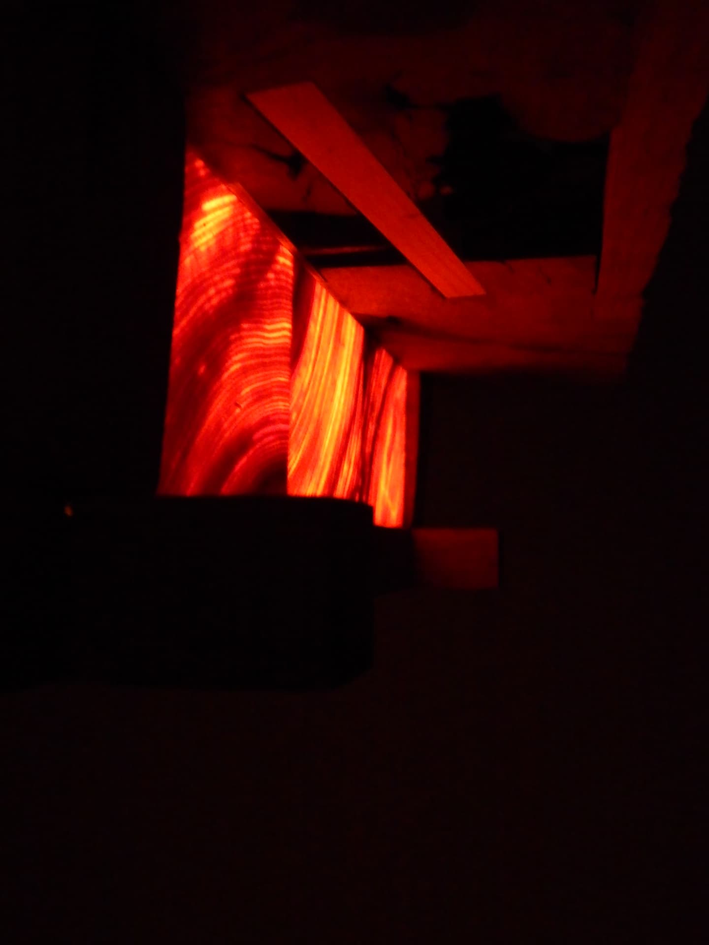 RIFT seen through a dark opening — resin panels glowing deep red within the room