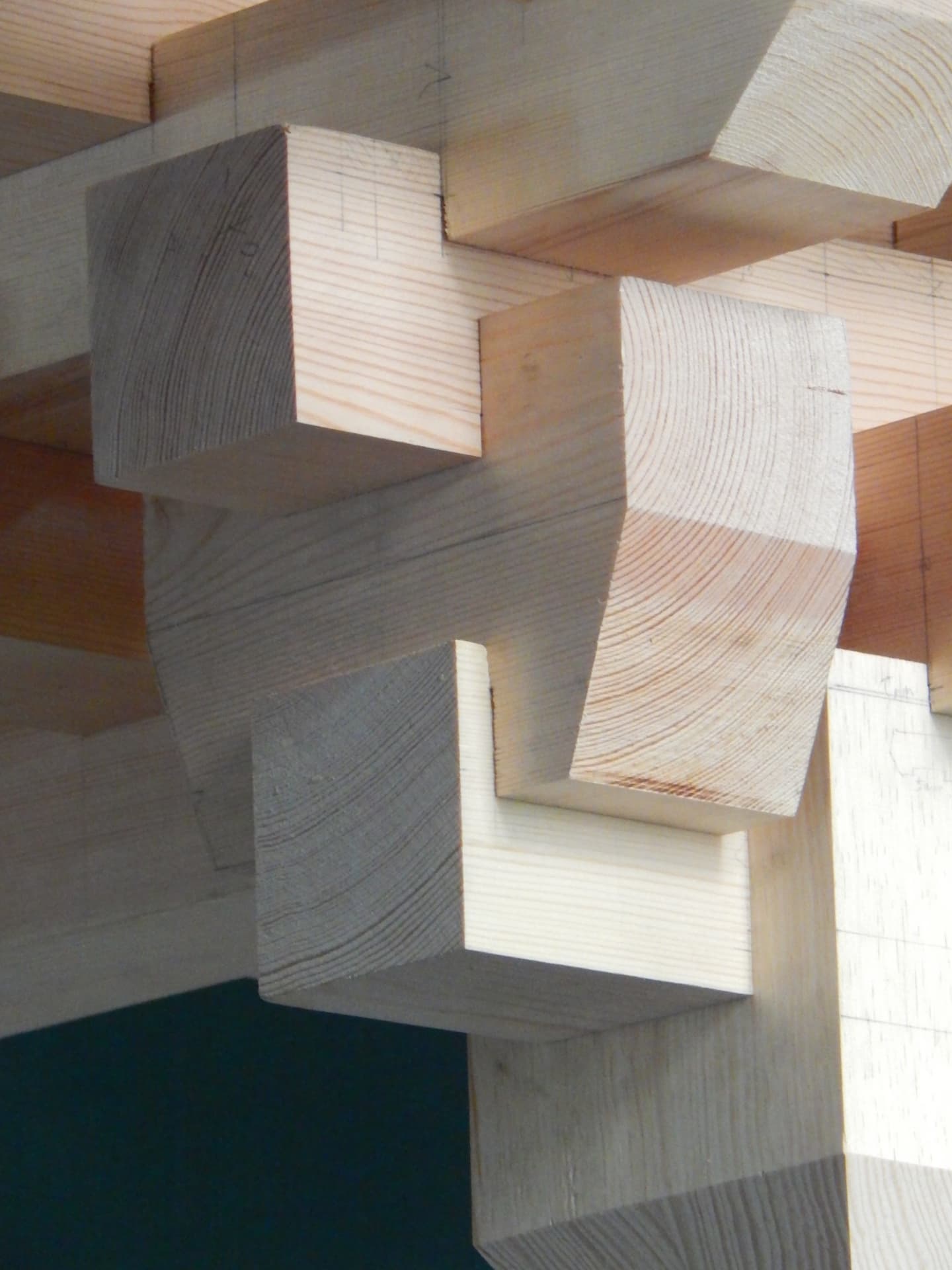 PASSAGE joinery detail — stacked timber blocks revealing end grain and joint geometry