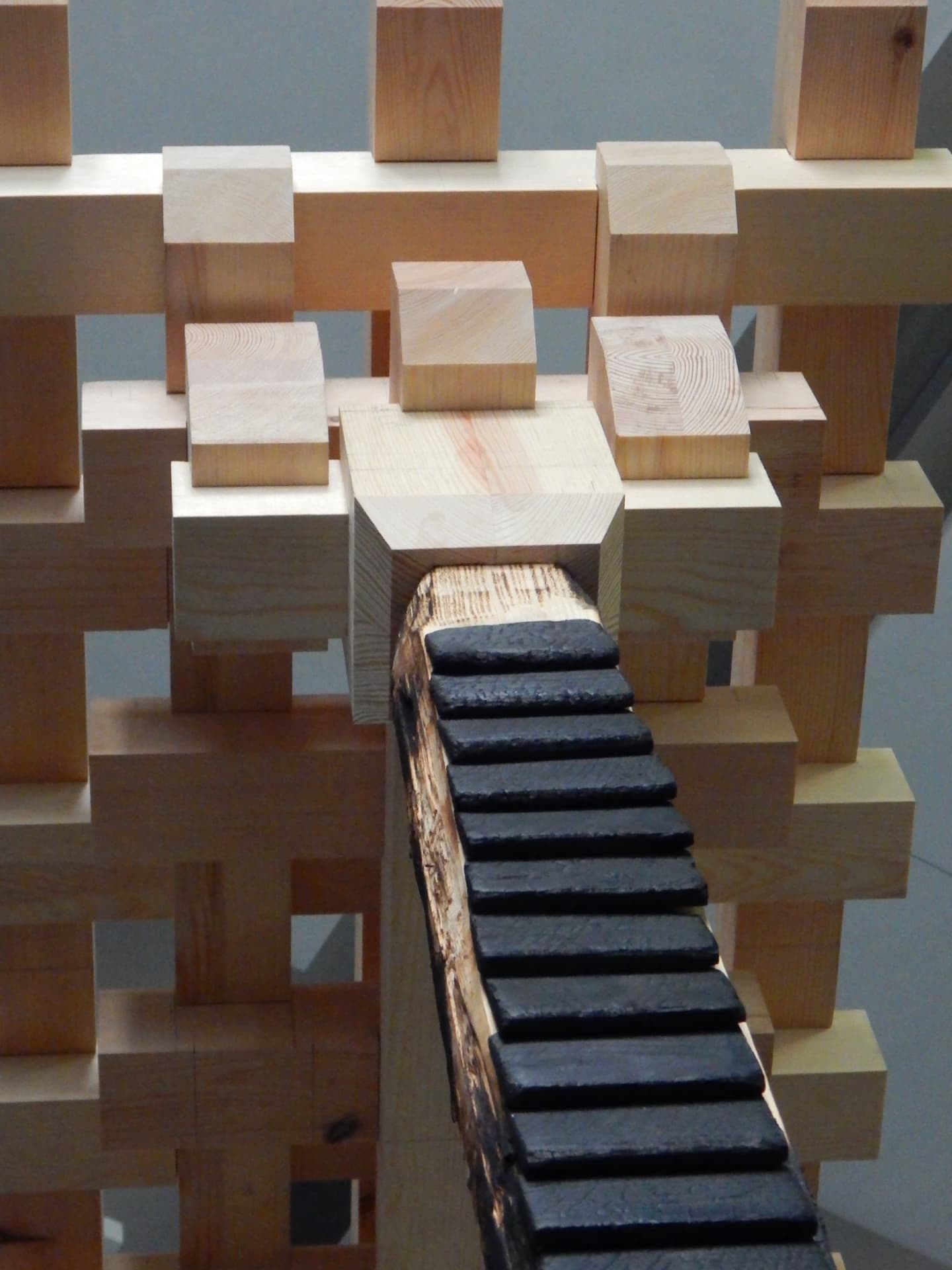 PASSAGE construction detail — charred stepped element entering the timber grid