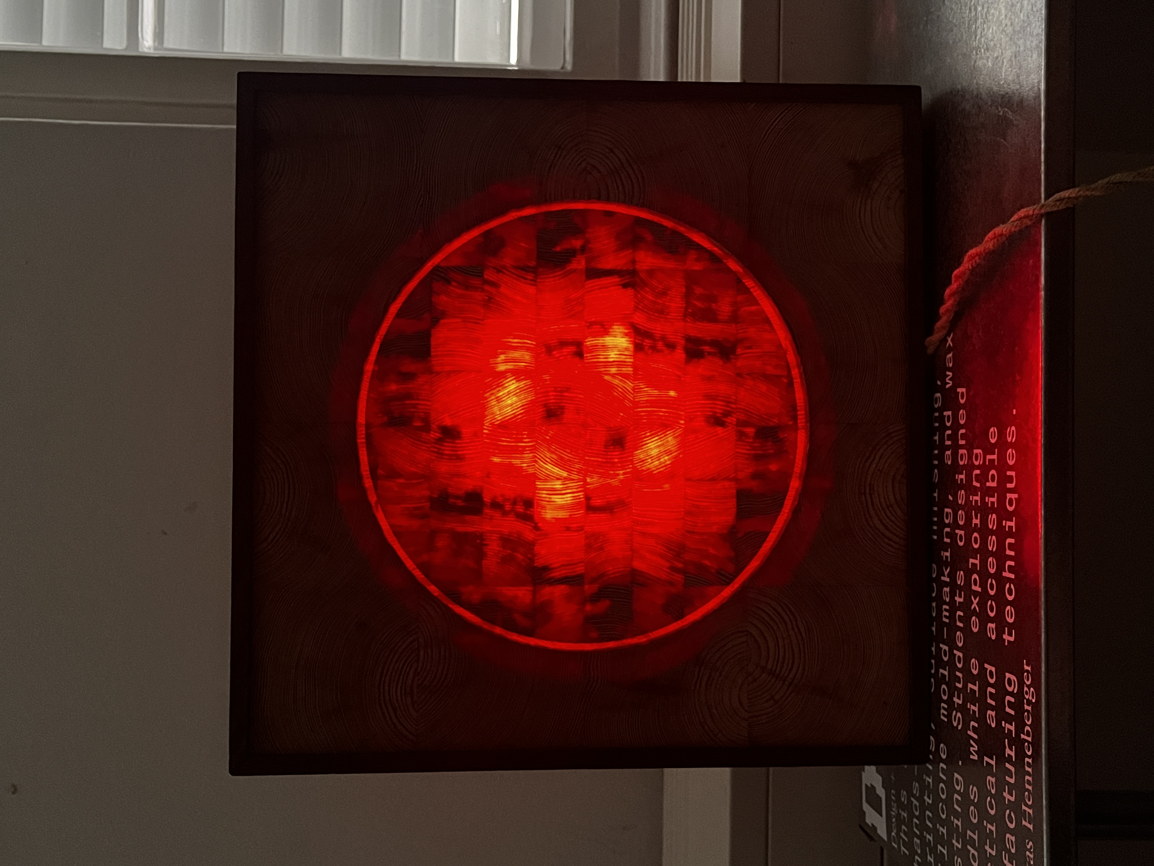 PULSE, glowing end-grain circle of the finished lamp in a dark room