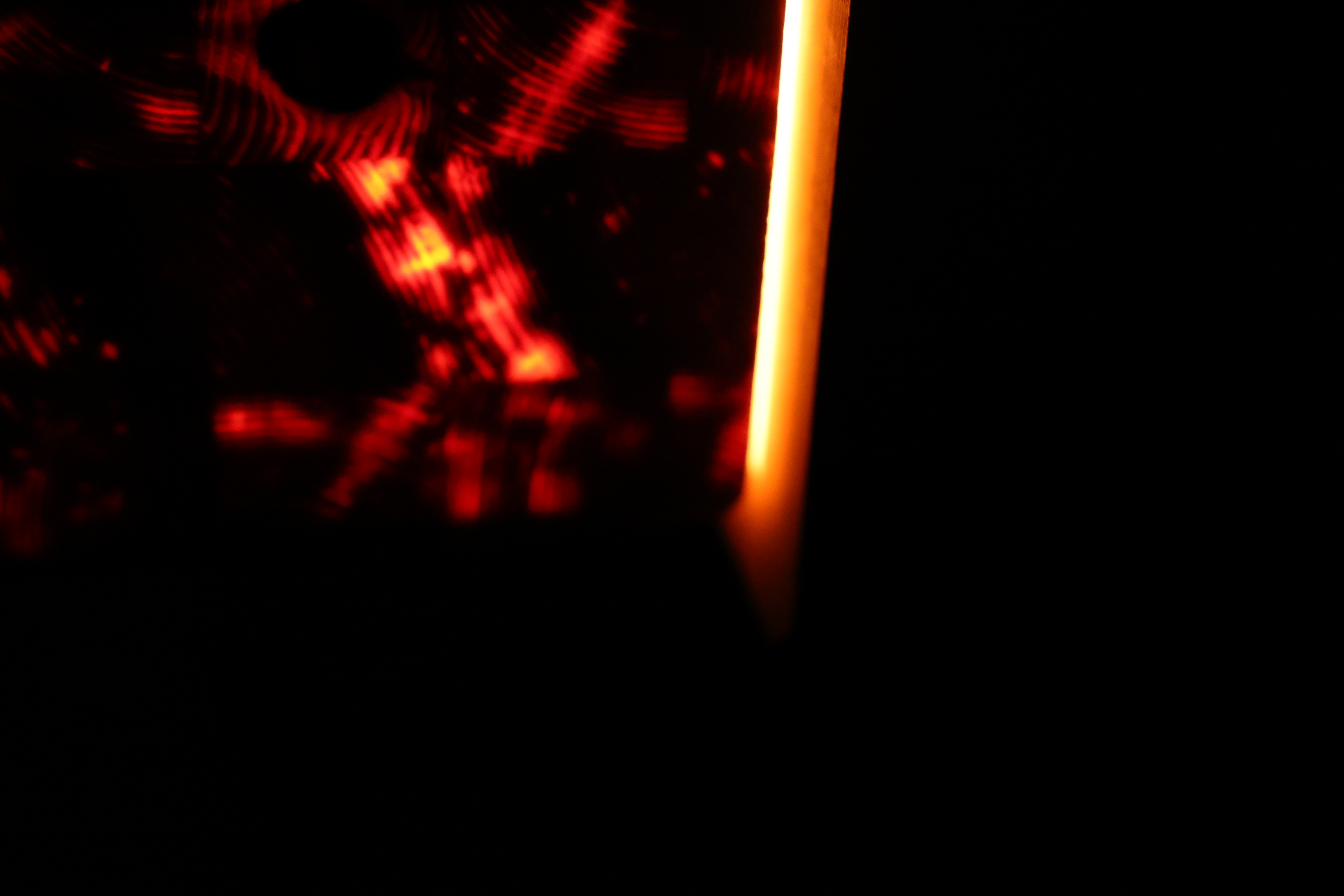SEED detail — warm light tracing the wooden edge in darkness