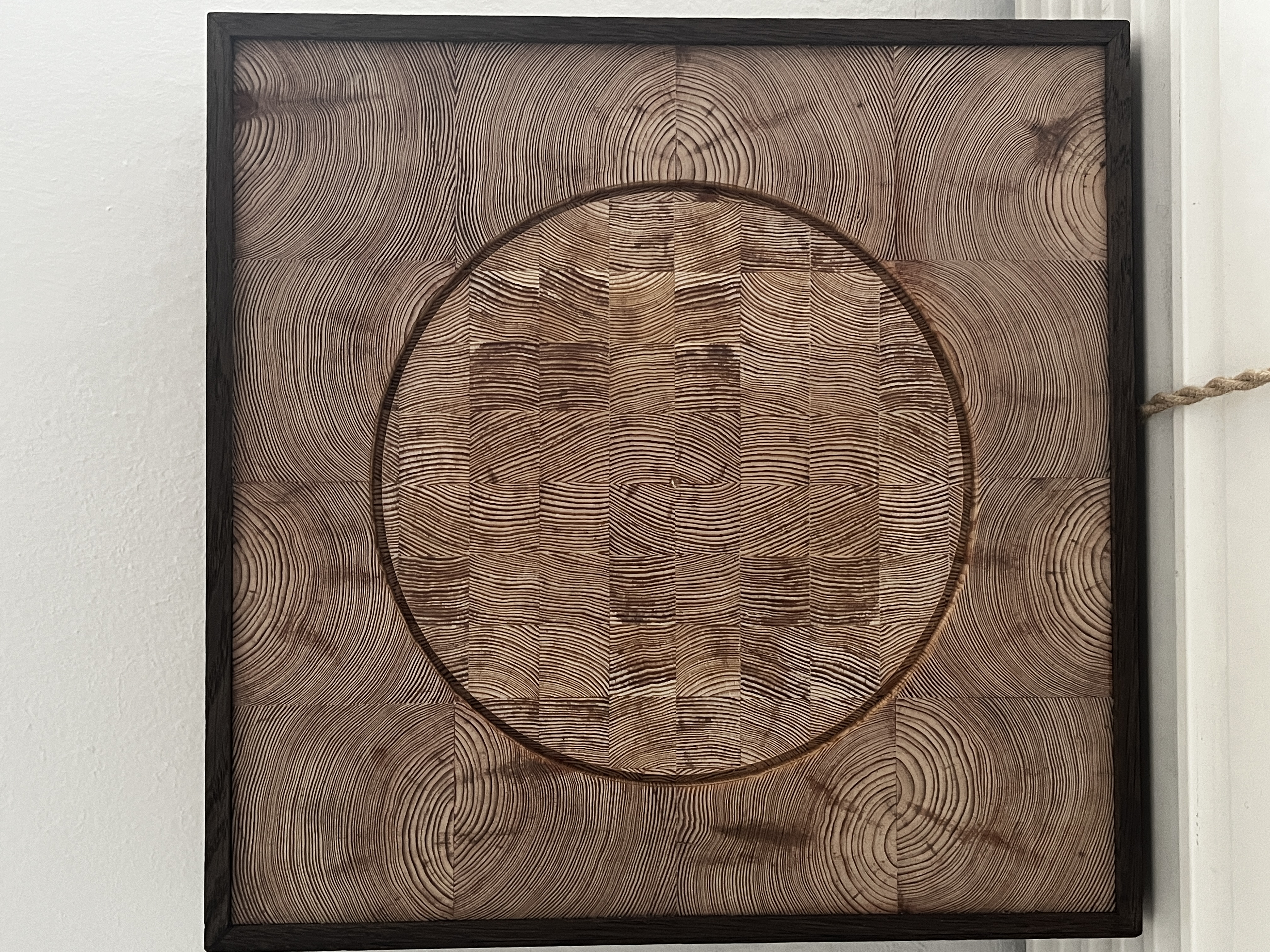PULSE in daylight — carved end-grain circle within its darkened wooden frame
